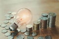 stack money coins with growing light bulb Royalty Free Stock Photo