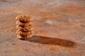 A stack of mouth-watering homemade oatmeal cranberry cookies on a harmonious textured cinnamon-colored background.