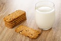 Stack of muesli cookie, glass of milk on wooden table