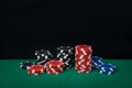 A stack of multi-colored chips for playing in a casino, on a green cloth of the table Royalty Free Stock Photo