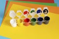 Stack of multi-colored paper and paint for drawing on a blue background. Royalty Free Stock Photo