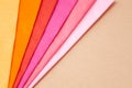 a stack of multi colored tissue paper spread out in a fan on a background of brown cardboard Royalty Free Stock Photo