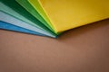 a stack of multi colored tissue paper spread out in a fan on a background of brown cardboard Royalty Free Stock Photo