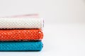 A stack of multicolored dense textiles with a braided texture on the white background