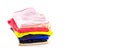 A stack of multicolored knitwear, t-shirts, stacked vertically, isolated on a white background. Banner. Royalty Free Stock Photo