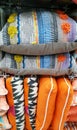 Stack of multicoloured cushions. Retail.