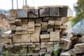 Stack of natural brown uneven rough wooden boards different size, cross-sectional view. Industrial timber for carpentry, building