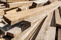 Stack of natural wooden boards on building site. Industrial timber for carpentry, building or repairing, lumber material for roofi