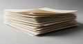 A stack of neatly aligned, off-white sheets of paper, placed on a gray surface. The papers are Royalty Free Stock Photo