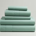 Stack of neatly folded bed linens in a soft aqua color. Made from smooth, possibly Royalty Free Stock Photo