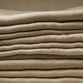 A stack of neatly folded beige linen fabric, layered on top of each other. The texture of Royalty Free Stock Photo
