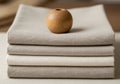 A stack of neatly folded, beige linen fabrics with a smooth texture is arranged in a Royalty Free Stock Photo