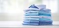 The stack of neatly folded blue shirts on a table in soft light. AI generated image Royalty Free Stock Photo