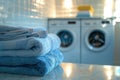 A stack of neatly folded blue towels sits on a countertop in front of two washing machines in a laundry room. Generative Royalty Free Stock Photo