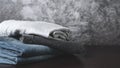 Stack of neatly folded dark clothes on a black-gray background close-up Royalty Free Stock Photo
