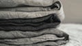 A stack of neatly folded linen sheets in various shades of gray. The fabric appears soft and textured, arranged in a Royalty Free Stock Photo
