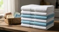 A stack of neatly folded towels, alternating between white and light blue, is placed on Royalty Free Stock Photo