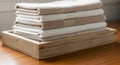 A stack of neatly folded towels is placed on a wooden surface. The towels are primarily white, with Royalty Free Stock Photo