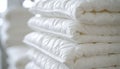Stack of neatly folded white comforters with stitched patterns Royalty Free Stock Photo