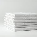 A stack of neatly folded white linens or sheets is arranged on a flat surface. The linens Royalty Free Stock Photo