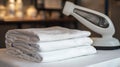 A stack of neatly folded white sheets with a white ironing tool symbolizing cleanliness order and preparation This image Royalty Free Stock Photo