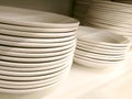 Stack of new clean white plain plates and bowls on the shelf Royalty Free Stock Photo