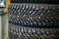 Stack of new winter studded tyre with metal spikes in store, rubber auto car wheels Royalty Free Stock Photo