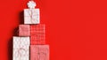 Stack of new year gift box in the shape of a Christmas tree on a red background. Flat lay top view copy space Royalty Free Stock Photo