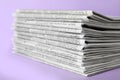 Stack of newspapers on light violet background. Journalist`s work Royalty Free Stock Photo