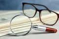 Stack of newspapers, magnifier and glasses on table. Search Royalty Free Stock Photo