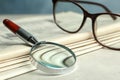 Stack of newspapers, magnifier and glasses. Search concept Royalty Free Stock Photo