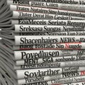 Stack of newspapers with various headlines and text in multiple languages Royalty Free Stock Photo