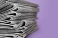 Stack of newspapers on violet background, closeup. Journalist`s work Royalty Free Stock Photo