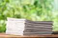 Stack of newspapers on table against blurred green background. Journalist`s work Royalty Free Stock Photo