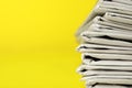 Stack of newspapers on yellow background, closeup with space for text Royalty Free Stock Photo