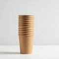A stack of nine brown disposable paper cups arranged vertically on a white surface. T Royalty Free Stock Photo