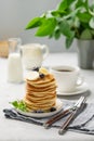 A stack of oat banana pancakes with fresh fruit slices, berries and honey on a light background with a cup of black coffee and Royalty Free Stock Photo