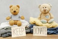 Stack of old baby children clothes,teddy bear toys,sorted into Keep and Donate categories.Donation,volunteering help,humanitarian