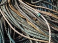 Stack of old blue coiled and knotted marine fishing rope in shades of blue and brown