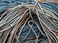 Stack of old blue coiled and knotted marine fishing rope in shades of blue and brown