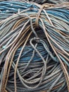 stack of old blue coiled and knotted marine fishing rope in shades of blue and brown