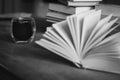 Stack of old books and coffee cup, black and white. Literature background. Open book and pile of books on the table. Royalty Free Stock Photo