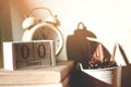 Stack old books with a cup of freshly coffee, vintage alarm clock, wooden calendar, on table in sunlight morning Royalty Free Stock Photo