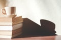 Stack old books with a cup of freshly coffee on wooden table in sunlight morning Royalty Free Stock Photo