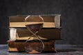 A stack of old books and an hourglass. The concept of time and knowledge Royalty Free Stock Photo
