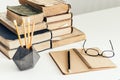 Stack of old books, open notebook, glasses and pencils in holder, education concept background, many books piles with copy space Royalty Free Stock Photo
