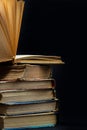 stack of old books with opened one on top on dark background. Old books in the library. Bookshelf shop. Knowledge publications, Royalty Free Stock Photo