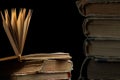 stack of old books with opened one on top on dark background. Old books in the library. Bookshelf shop. Knowledge publications, Royalty Free Stock Photo