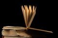 stack of old books with opened one on top on dark background. Old books in the library. Bookshelf shop. Knowledge publications, Royalty Free Stock Photo