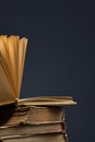 stack of old books with opened one on top on dark background. Old books in the library. Bookshelf shop. Knowledge publications, Royalty Free Stock Photo